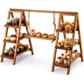 A wooden A-frame dessert display stand with rope hanging elements, shown on a white background and filled with cupcakes, muffins, pastries, and small fruit desserts.