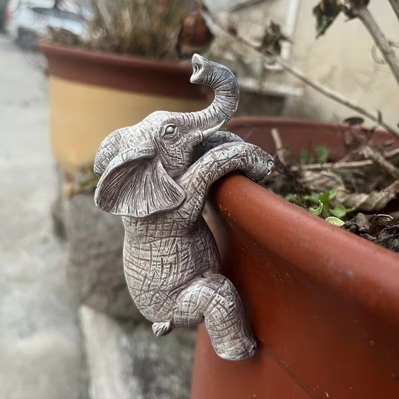 Dkor Ltd grey resin elephant pot hugger figurine with detailed texture, perched on a terracotta pot rim.